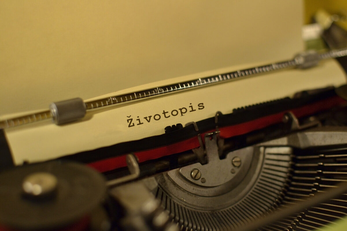 Detail starého písacieho stroja s papierom a nápisom „Životopis“.